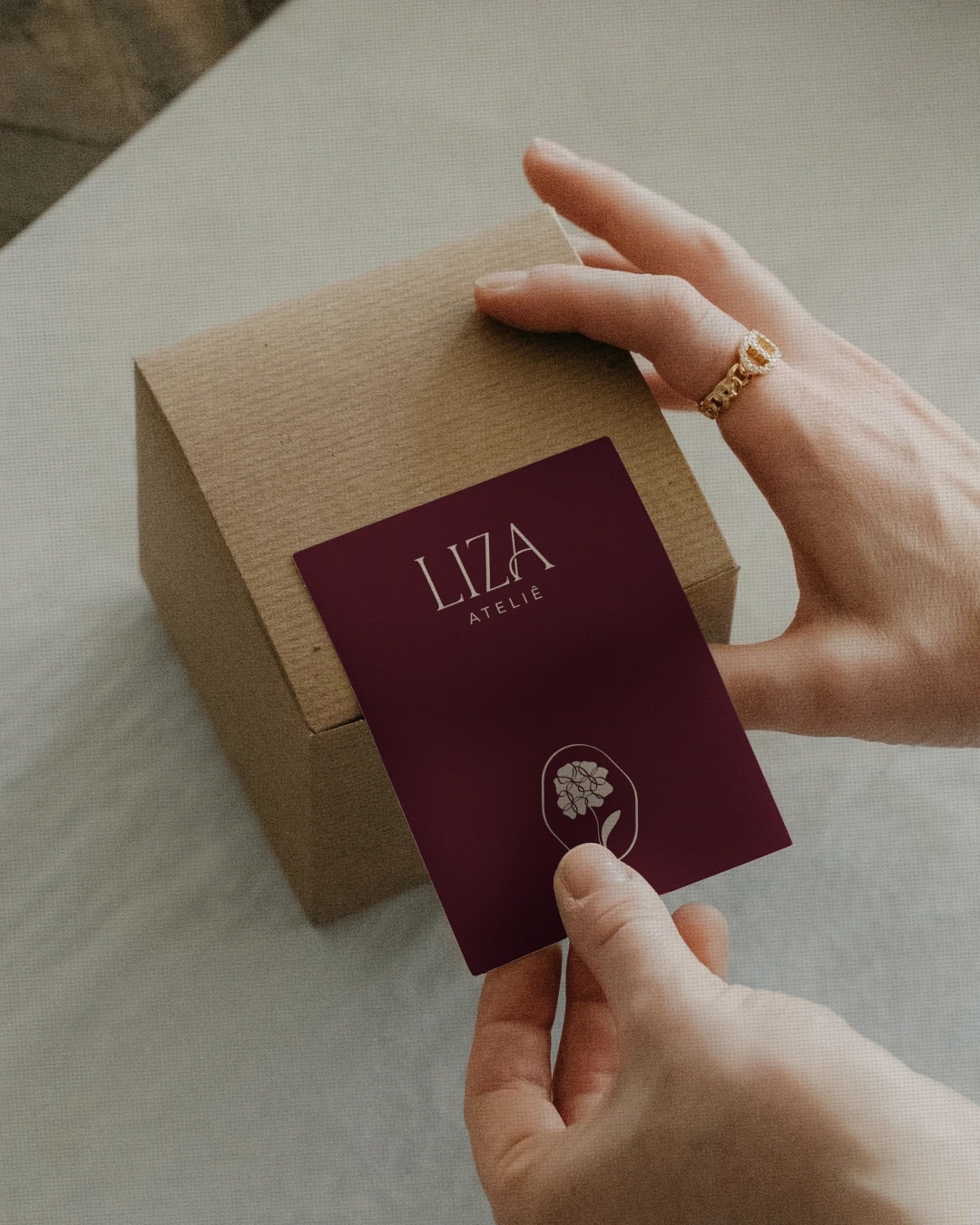 Cartão vinho da marca apresentado junto a uma caixa kraft do projeto ELISA MOREIRA